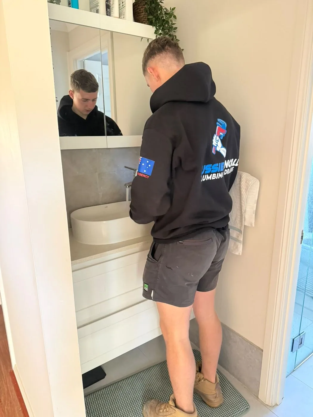 Plumber fitting a new basin mixer tap