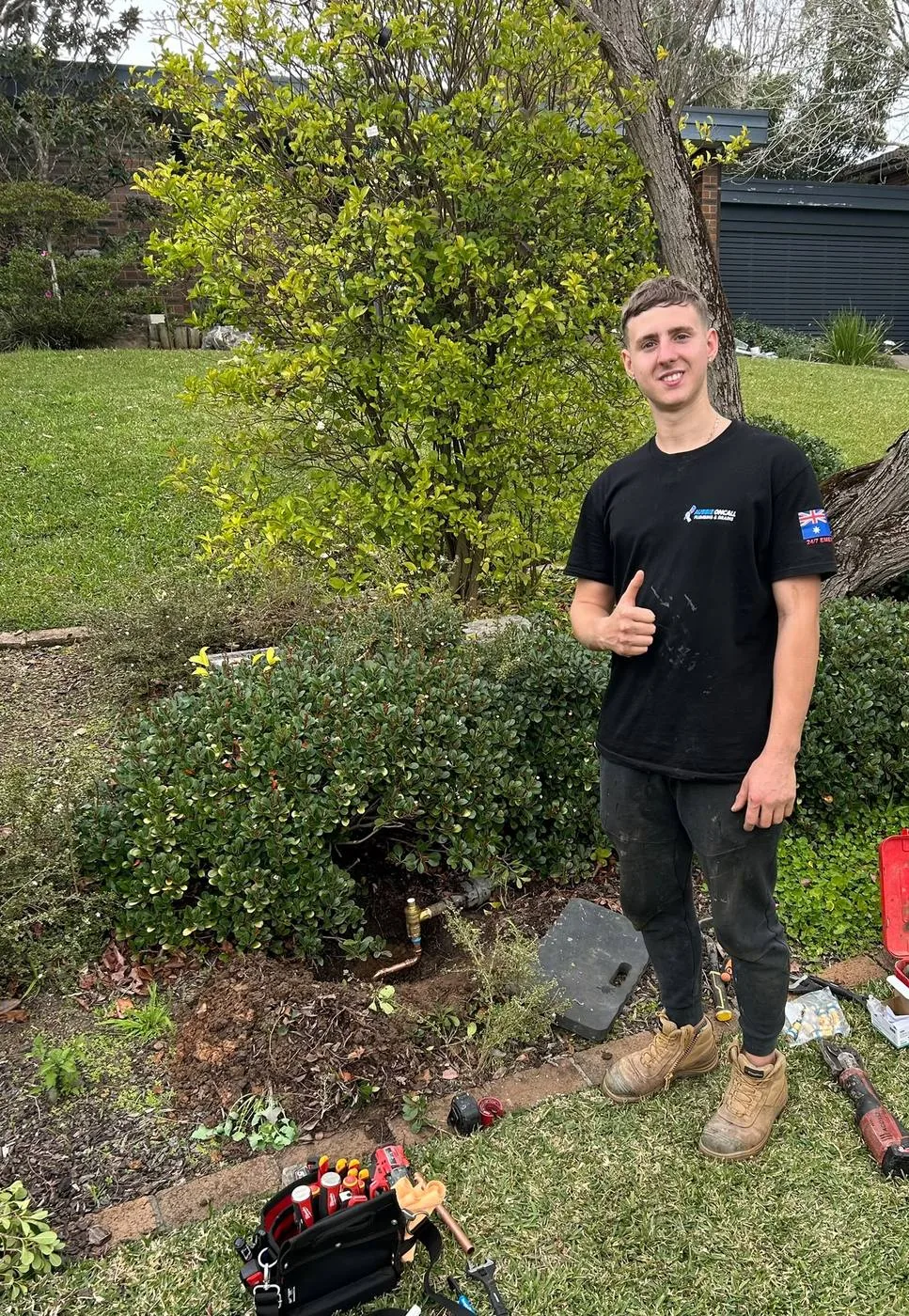 Plumber after installing an outdoor tap in a back garden