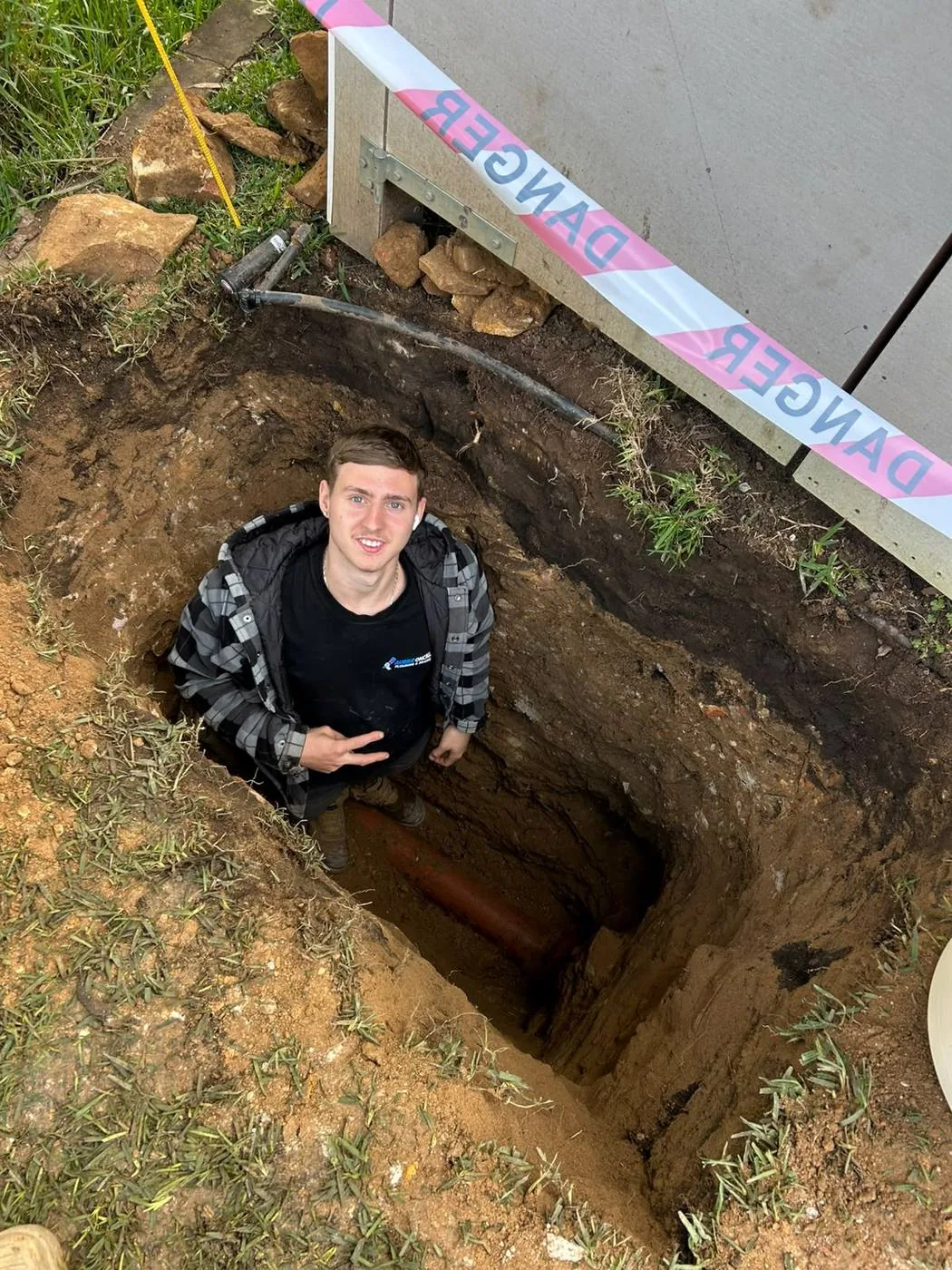 Plumber in the excavation for a sewer repair