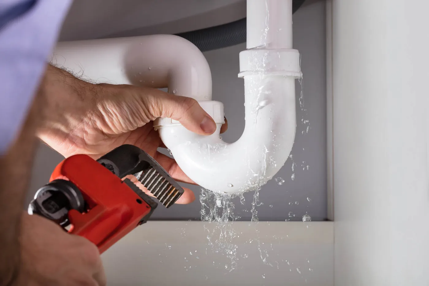 A leaking pipe joint under a sink