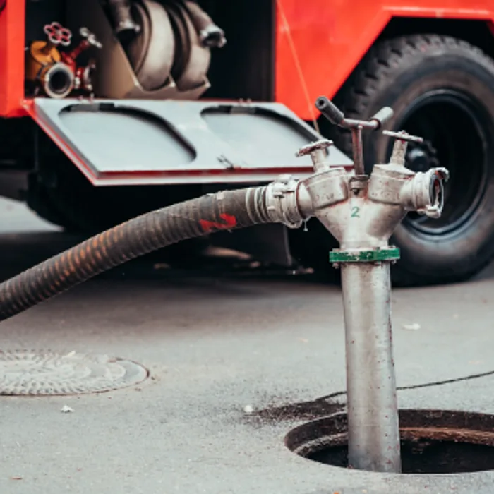 Vacuum truck pumping out a surcharged sewer access point